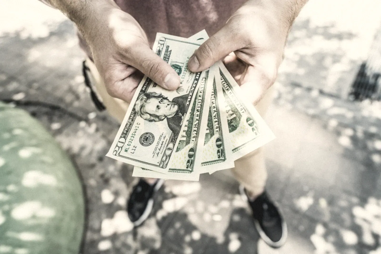 Hands counting a stack of dollar bills